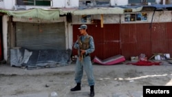 An Afghan policeman stands guard at the site of a deadly suicide attack in Kabul on September 29.