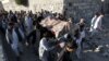 Relatives and residents carry a coffin for burial of one of the victims of a suicide attack in Asadabad, the capital of Kunar Province, on February 27.