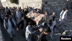 Relatives and residents carry a coffin for burial of one of the victims of a suicide attack in Asadabad, the capital of Kunar Province, on February 27.