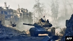 Syrian pro-government forces drive a tank through a newly retaken district of Aleppo's Old City on December 8. 