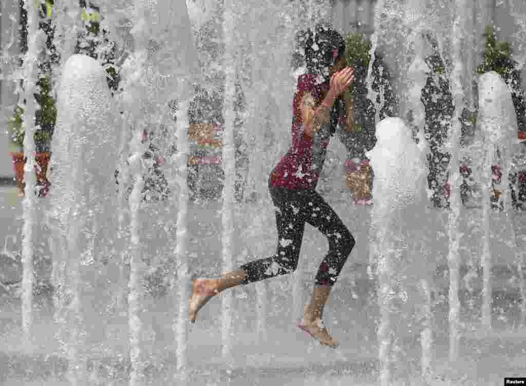 A girl cools off in a fountain in central Donetsk, one of the host cities of the Euro 2012 soccer championship. (Reuters/Yves Herman) 