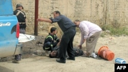 Rescuers help a victim following a mortar attack on the western city of Ramadi, the provincial capital of Anbar province on April 15. 