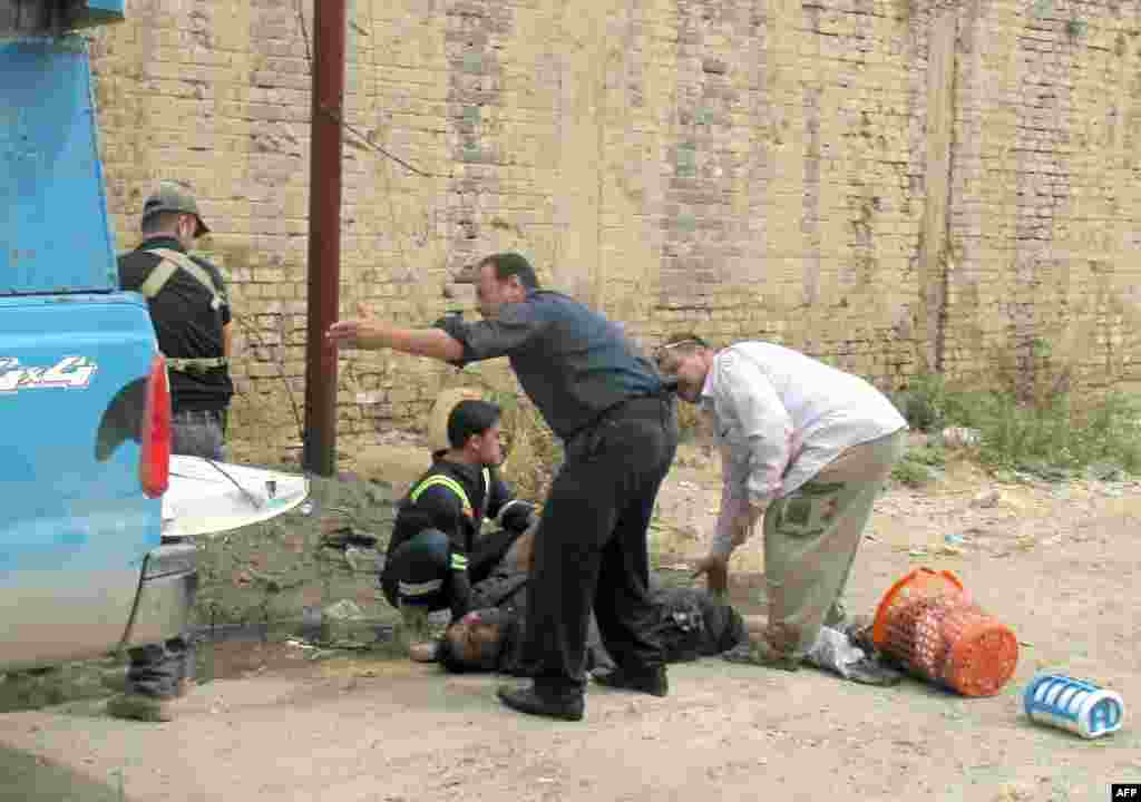 Civilians have also lost their lives. People help the victim of a mortar attack in Ramadi.