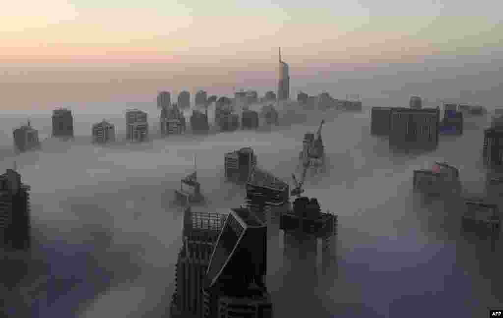 Skyscrapers are seen amid the clouds on a foggy morning in Dubai. (AFP/Rene Slama)