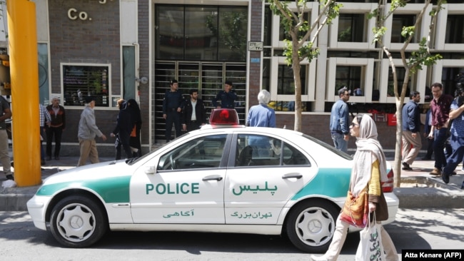 Një veturë e policisë iraniane e parkuar para një dyqani të këmbimit të monedhave në Teheran. 10 prill, 2018