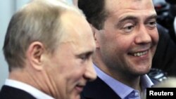 Prime Minister Vladimir Putin (left) and President Dmitry Medvedev try to smile as they visit the headquarters of the United Russia party after voting closed in Moscow on December 4.