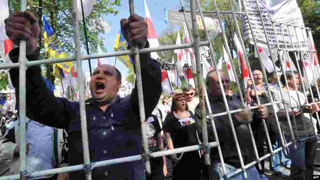 A supporter of jailed Ukrainian opposition leader Yulia Tymoshenko carries a symbolic prison bar during a rally calling for her release in Kyiv on April 27. (AFP/Sergei Supinsky)