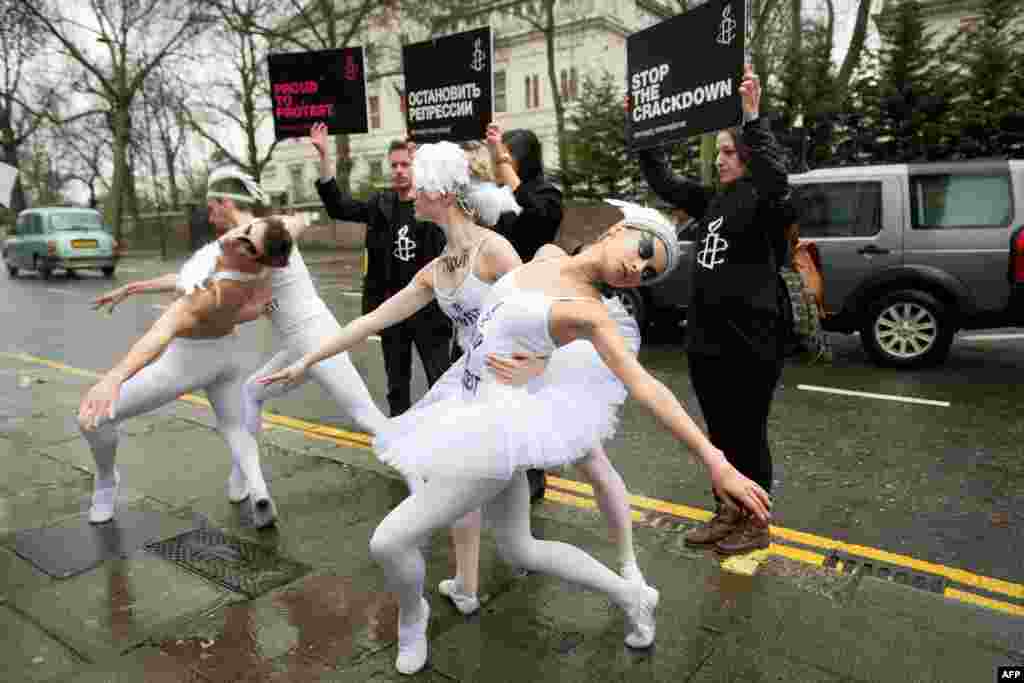 Ballet dancers prepare to perform a scene from &quot;Swan Lake&quot; during a protest near the Russian Embassy in London to protest Russian antigay legislation, organized by Amnesty International ahead of the Sochi Winter Olympics. (AFP/Leon Neal)