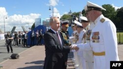 President Vladimir Putin greets top military officials during a Navy Day parade in Saint Petersburg on July 26.