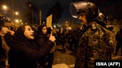 A woman attending a candlelight vigil in memory of the victims of the plane crash confronts a policeman following the gathering in front of Amir Kabir University in Tehran on January 11.