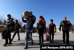 Afghan refugees cross the border into Afghanistan after being deported by Iran in December 2017.