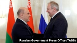 Russian Prime Minister Mikhail Mishustin (left) greets his Belarusian counterpart, Syarhey Rumas, in Moscow on March 11.