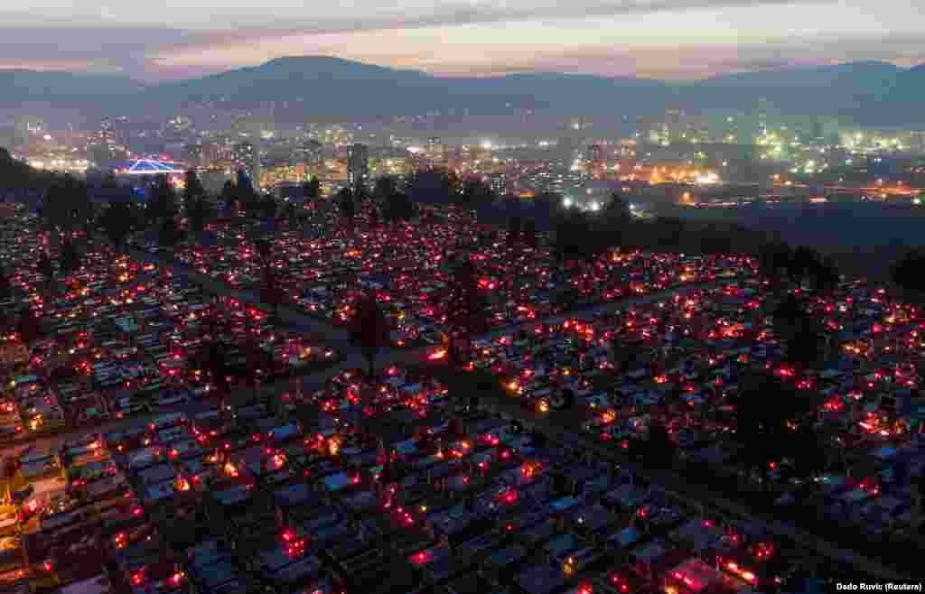 The glow of candles and lamps from the cemetery on Crkvicko hill cemetery with the city lights of&nbsp; Zenica in the background