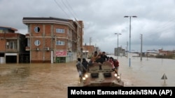 Military boats rescue people after flash flooding around the northern city of Aq Qala in Golestan province, Iran, Monday, March 25, 2019