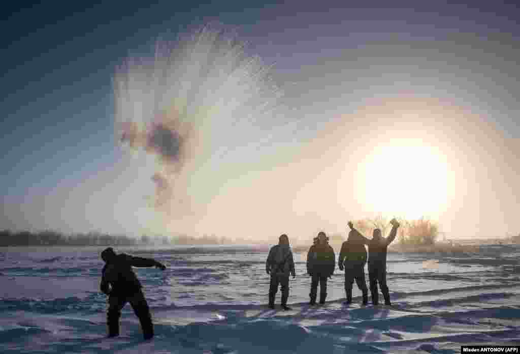 A villager throws hot water into the air to watch it freeze while harvesting ice from a local lake near the settlement of Oy, some 70 kilometers south of Yakutsk, where the air temperature was minus 41 Celsius. Many people in the Yakutia Republic depend on melted ice as there is no other way to supply water due to the extremely cold temperatures. (AFP/Mladen Antonov)
