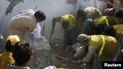 Rescue workers look for survivors in the rubble of the Federal Investigation Agency, which was hit by a suicide bomb blast in Lahore today.