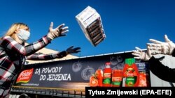 Radnici utovaraju u kamion osnovne životne namirnicama u Bydgoszczu, Poljska, 8. april. Dve poljske firme, Polski Cukier i Polskie Przetwory donirale su prehrambene proizvode za pomoć onima kojima je najpotrebnija usled pandemije korona virusa.