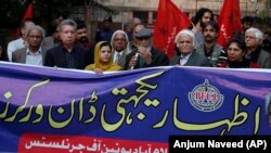 Pakistani journalists and rights activists hold a banner reading "Solidarity With Dawn Workers" during a demonstration in Islamabad on December 5.