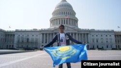Молодой человек с казахстанским флагом фотографируется на фоне Капитолия в Вашингтоне. 