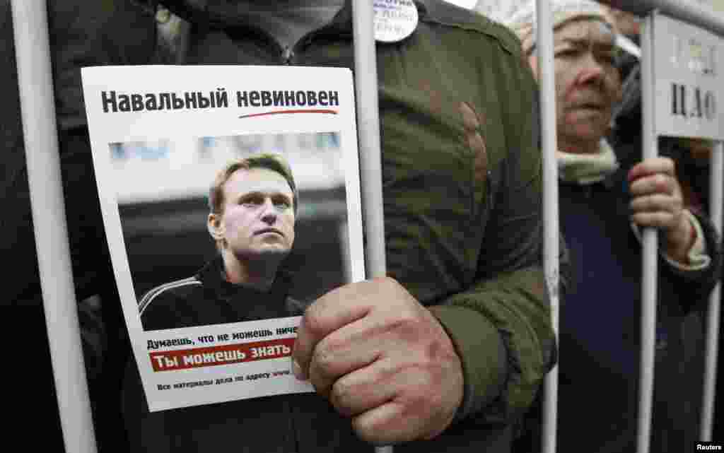 A man holds a portrait of opposition figure Aleksei Navalny.