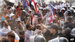 Anti-Mubarak protesters throw sand at riot police as they clash outside the police academy court in Cairo on September 5.