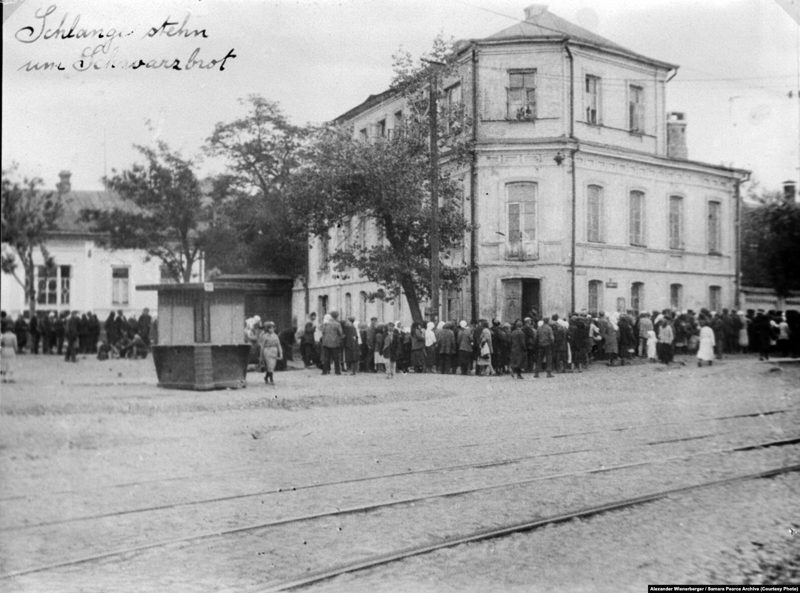 «Черга за чорним хлібом» (авторський підпис). Центральна частина Харкова, 1933 рік. Фото Александра Вінербергера. Надано власником авторських прав Самарою Пірс. Вперше надруковано у книзі «Національна книга пам’яті жертв Голодомору. Харківська область. 2018 рік»