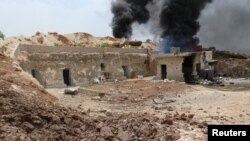 Клубы дыма после удара авиации по деревне повстанцев Маар Зита в провинции Идлиб, 27 апреля 2017 года