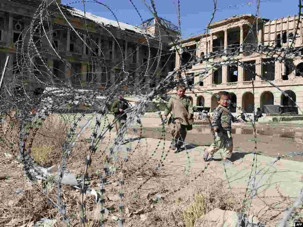 Kuchi boys walk in front of the ruined Darlaman Palace, which was destroyed during the civil war, on the outskirts of Kabul on October 27. More than 300 Afghan Kuchi tribal nomads settled into the palace several months ago under the protection of Afghan paramilitary police who use the ruins as a makeshift patrol base, after being driven from a nearby area in Kabul during a bout of ethnic riots earlier this summer.Photo by Shah Marai for AFP