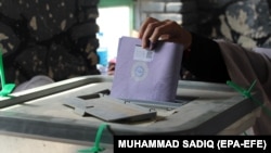 An Afghan man casts his vote during problem-plagued parliamentary elections in Kandahar on October 27.