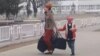 Turkmenistan. Mother with a big bags and child walking. Streets of Ashgabat. Living houses. January 2020