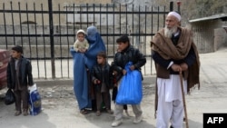 Afghan families wait to enter Pakistan at the Torkham border crossing between Afghanistan and Pakistan on February 17.