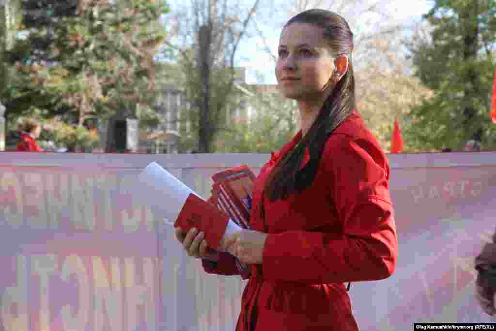 Дівчина роздає партійні квитки новим учасникам партії «Комуністи Росії»