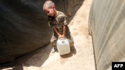 طفل يكافح في نقل حاوية ماء بوزنه لعائلته التي فرّت من الرمادي