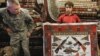 AFGHANISTAN -- an Afghan carpet trader displays a carpet showing different weapons 