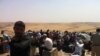 Kurdish refugees wait on the Iraqi side of the border after arriving from Syria. 