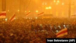 Supporters of opposition leader Alyaksandr Milinkevich gather in a square in Minsk during a heavy snow storm, with some demonstrators waving the banned Belarusian flag on March 19, 2006.