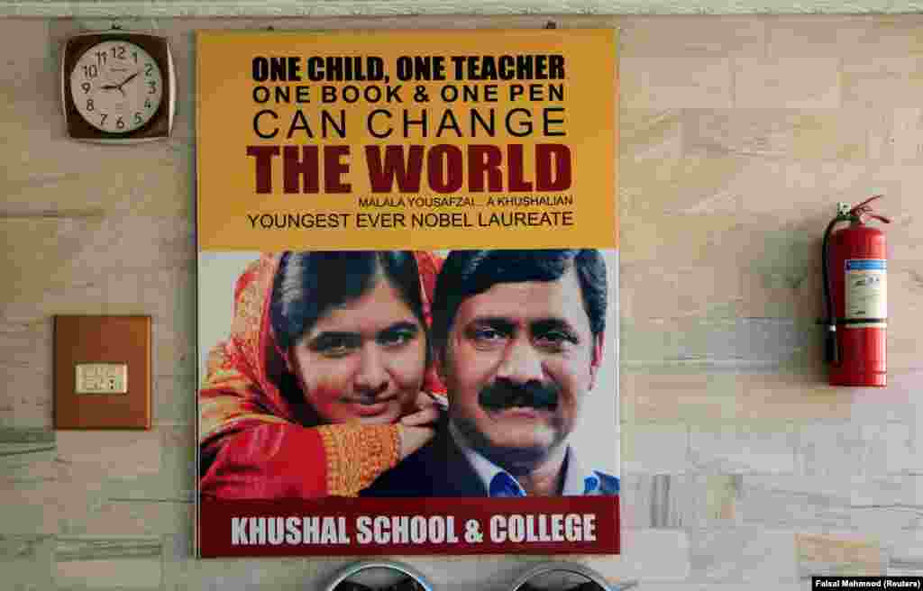 A poster with the pictures of Yousafzai and her father, Ziauddin, hangs on the wall of a school in her home district in the Swat Valley on March 30, 2018.