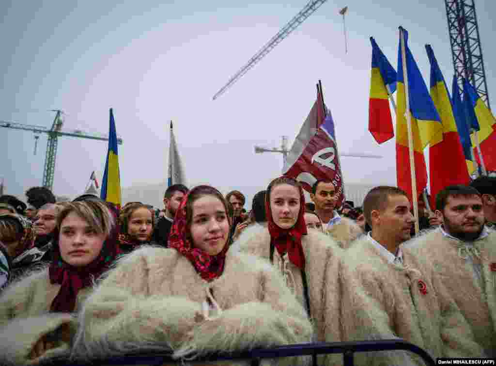 Romanians wearing traditional clothing take part in the consecration service of the Romanian People&#39;s Salvation Cathedral, which is still under construction in Bucharest. Tens of thousands of worshippers attended the inauguration of the massive new Orthodox cathedral amid criticism that public funding for the project could be better used to pay for hospitals and schools. (AFP/Daniel Mihailescu)