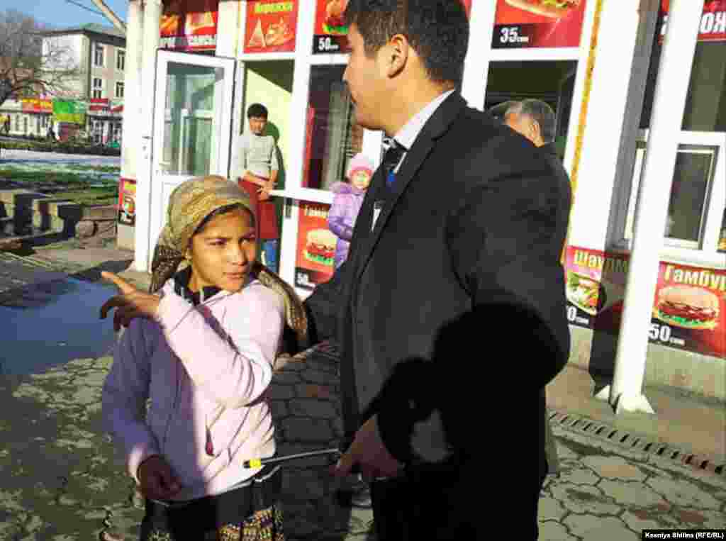 A security guard escorts a girl away from a restaurant. 