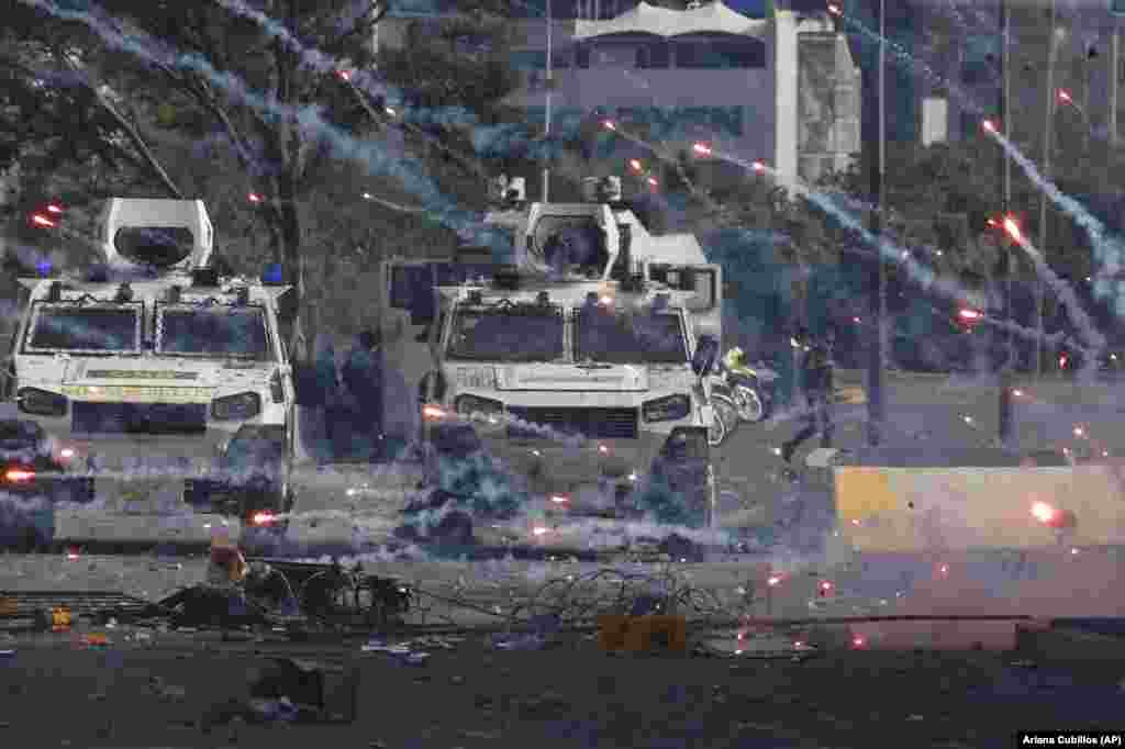 Fireworks launched by opponents of Venezuela's President Nicolas Maduro land near Bolivarian National Guard armored vehicles loyal to Maduro in Caracas on April 30. (AP/Ariana Cubillos)