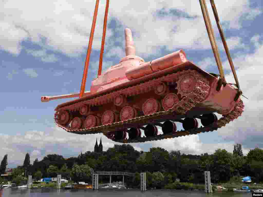 A Soviet WW II tank painted pink is loaded on a boat to be transported to Prague's city center on June 20. The tank had stood in Prague for more than 40 years as a monument to the Red Army's liberation of the city in 1945. Visual artist David Cerny controversially painted it pink in April 1991. The tank was brought back to Prague from a military museum as part of commemorations to mark the 20th anniversary of the departure of Soviet troops .Photo by Petr Josek for Reuters 