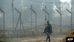 An Indian Border Security Force soldier patrols along the border fence at an outpost along the India-Pakistan border in Suchit-Garh on January 10.