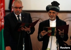 Owgan prezidenti Aşraf Gani (sagda) we wise-prezident Abdul Raşid Dostum kasam kabul edýär. Kabul, 29-njy sentýabr, 2014.