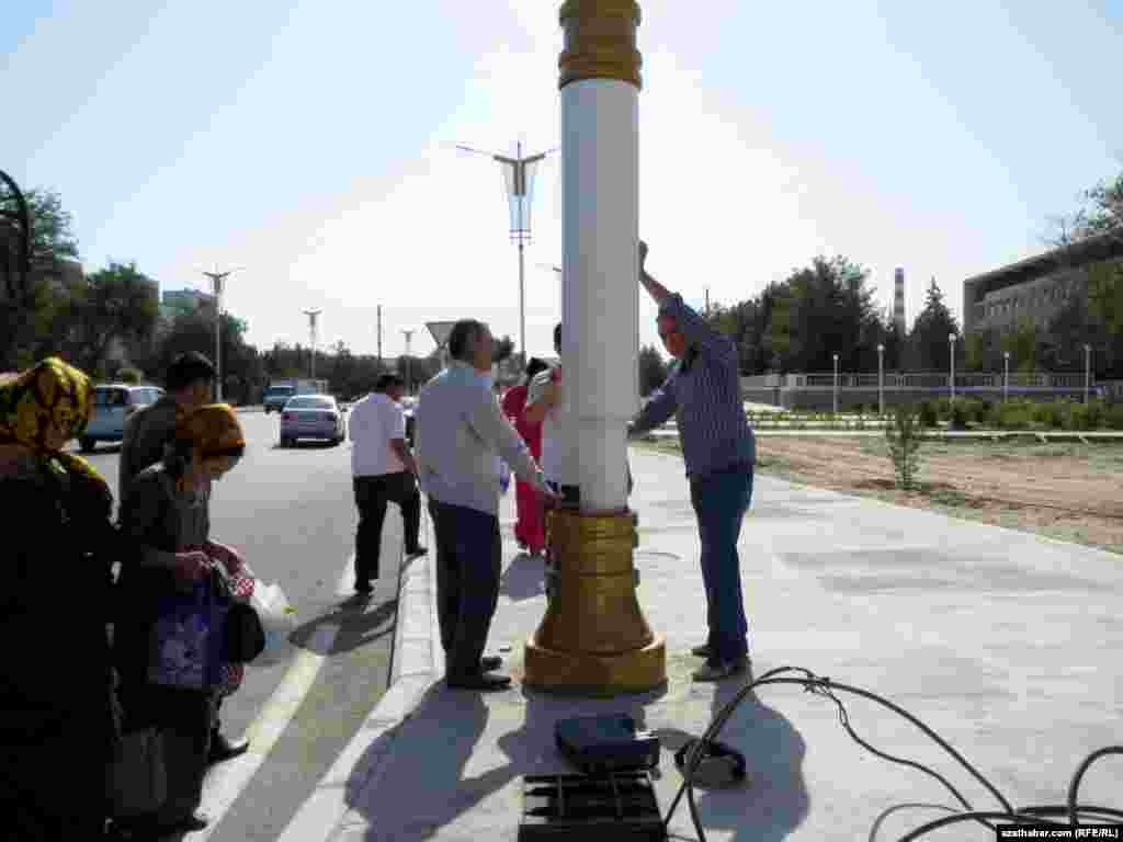 Aşgabadyň Oguzhan köçesiniň ugrundaky elektrik geçirijileri barlap duran işgärler.