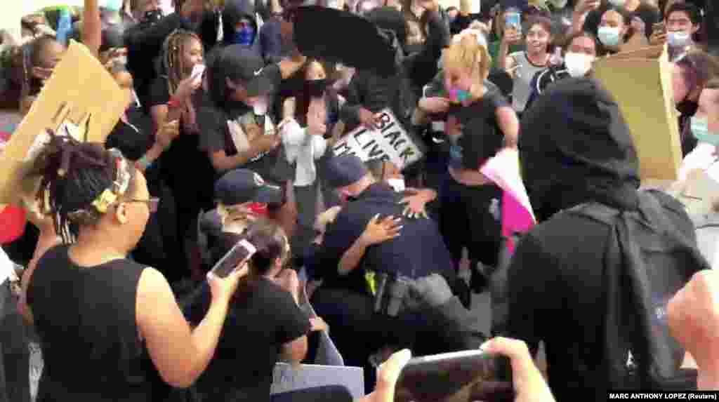 Oakley police chief Eric Christensen hugs a protester as he takes a knee with protesters demonstrating against the death of George Floyd in Minneapolis, in Oakley, California, U.S. in this still picture obtained from May 31, 2020 social media video. 