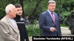 Ukrainian President Petro Poroshenko (right) speaks to reporters after the return of Hennadiy Afanasyev (center) and Yuriy Soloshenko (left).