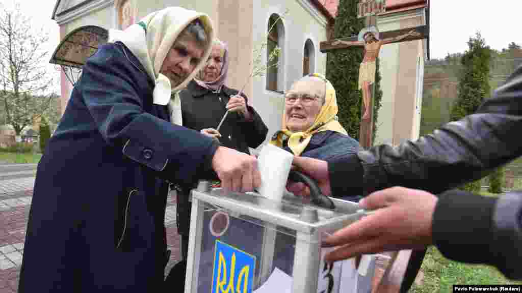 Місцева жителька кидає бюлетень до мобільної скриньки під час другого туру президентських виборів у селі Майдан Львівської області