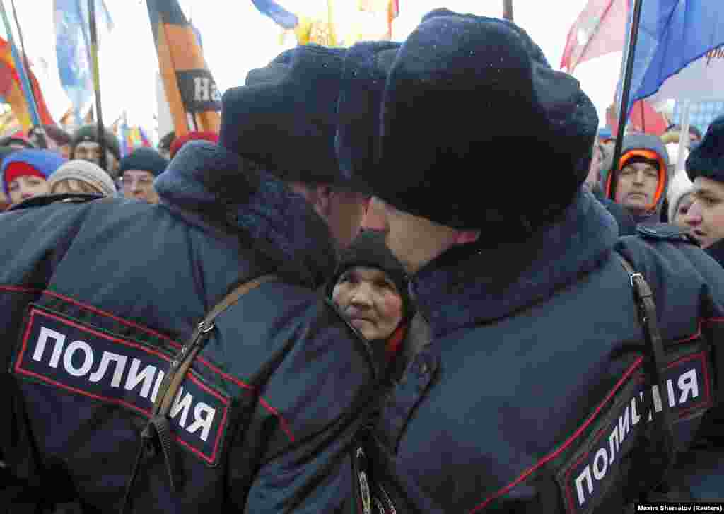 A woman watches Russian police officers during a March 18 concert in Moscow&#39;s Red Square marking the second anniversary of Russia&#39;s annexation of the Crimean peninsula. (Reuters/Maxim Shemetov)