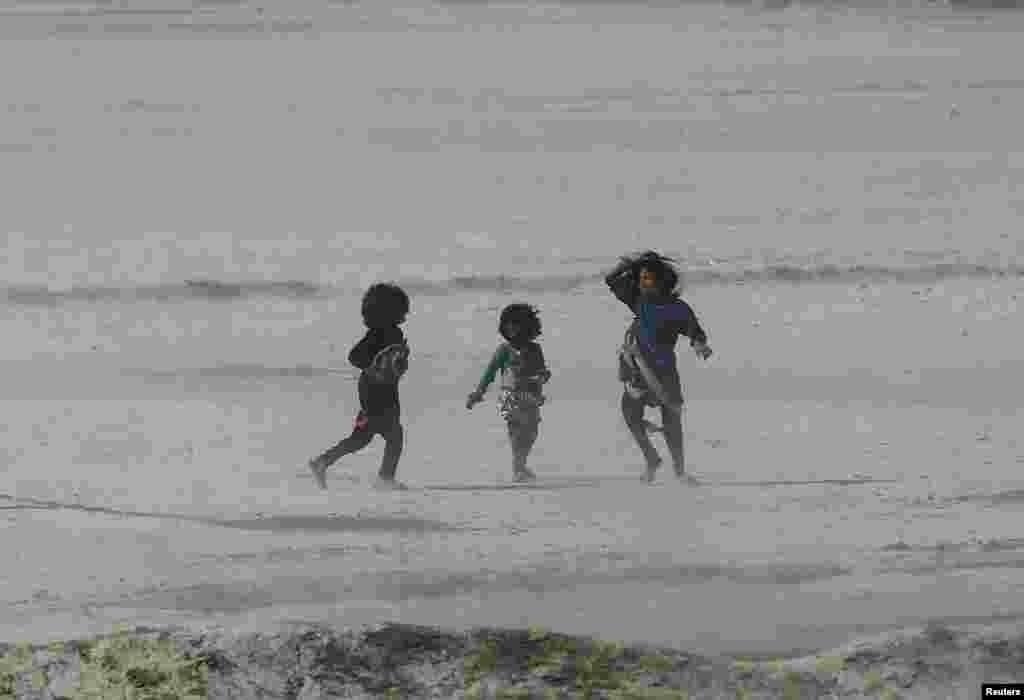 Afghan children walk get caught up in a dust storm in Kabul. (Reuters/​Mohammad Ismail)