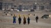 Kuchi women carry water on their heads on the outskirts of Kabul in late November.